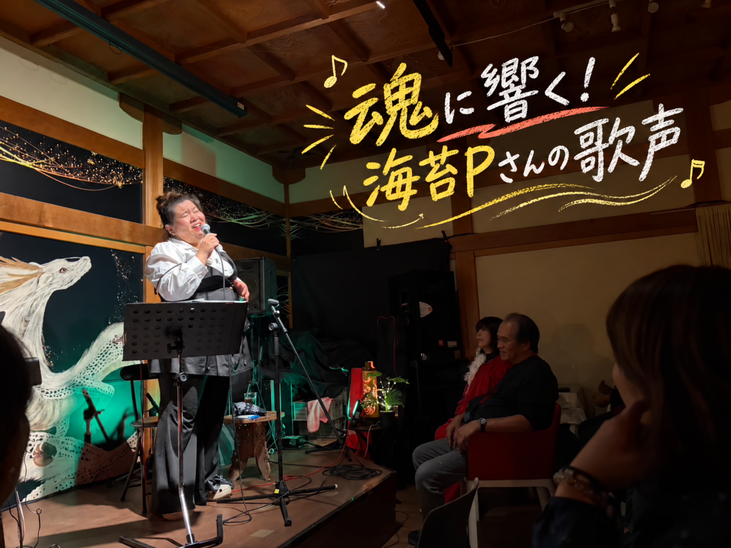 お堂カフェMA-A-NAの舞台で歌う海苔Pさん