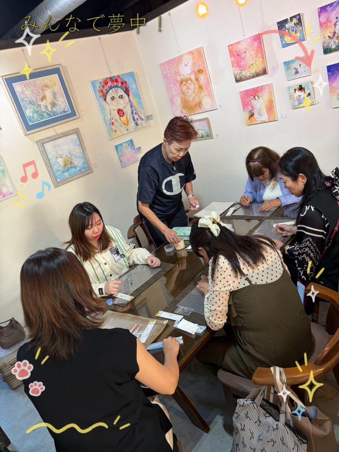 ネウネウの作品に囲まれたテーブルでスワロネックレスを作る参加者の皆さん